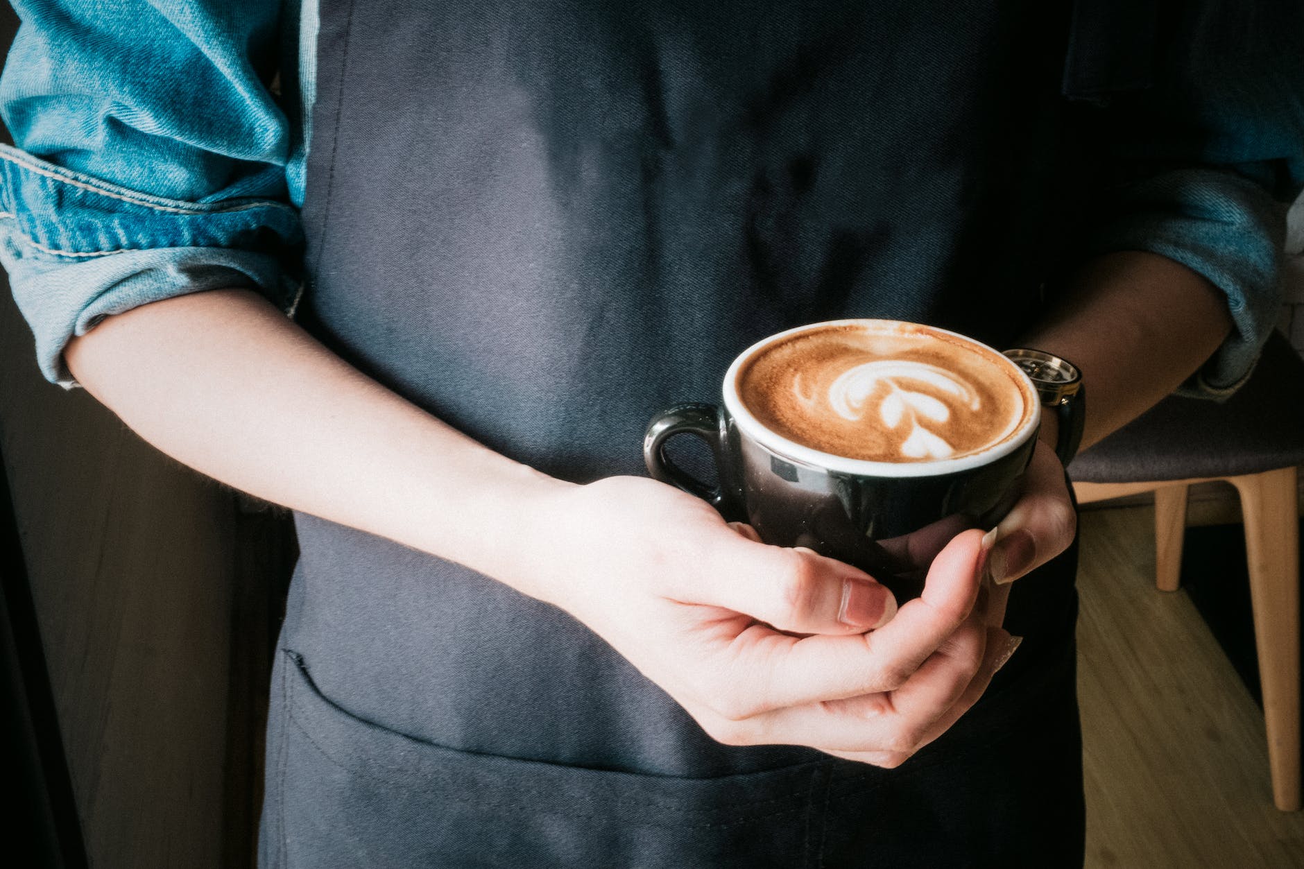 woman holding mug of cappuccino