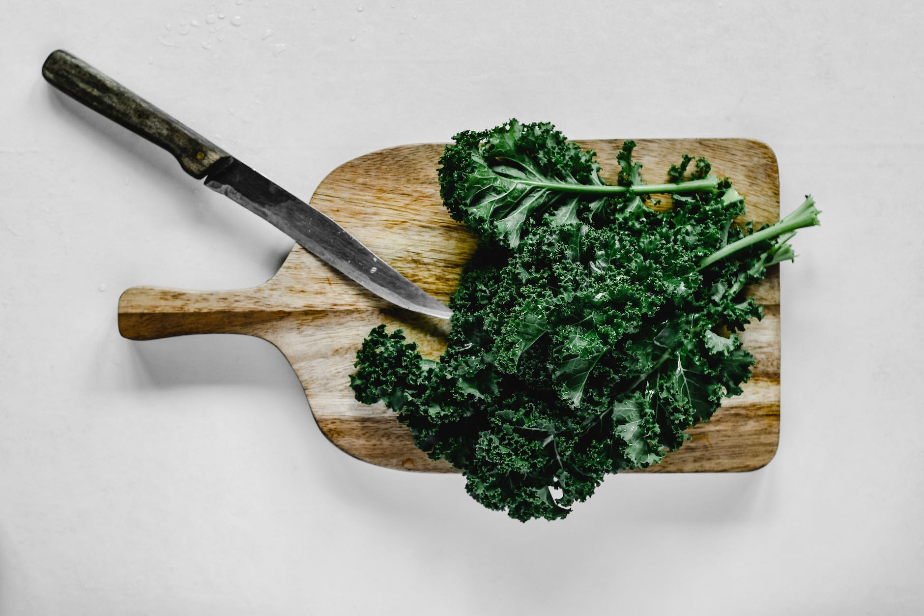 close up shot of kale on a wooden chopping board