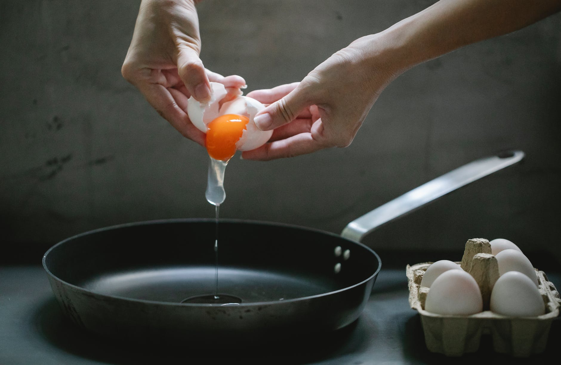 woman cooking eggs on pan