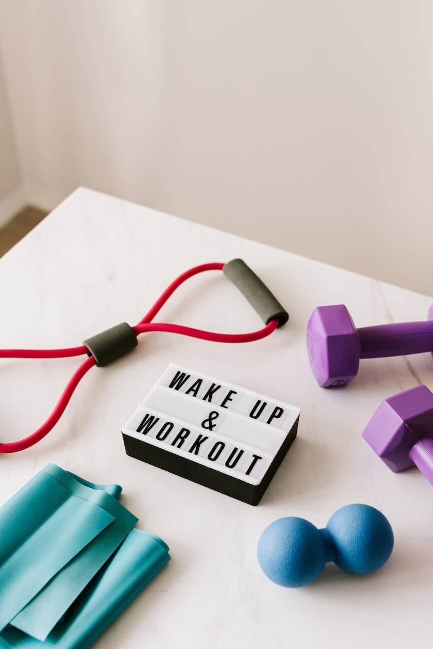 wake up and workout slogan on light box among sports equipment