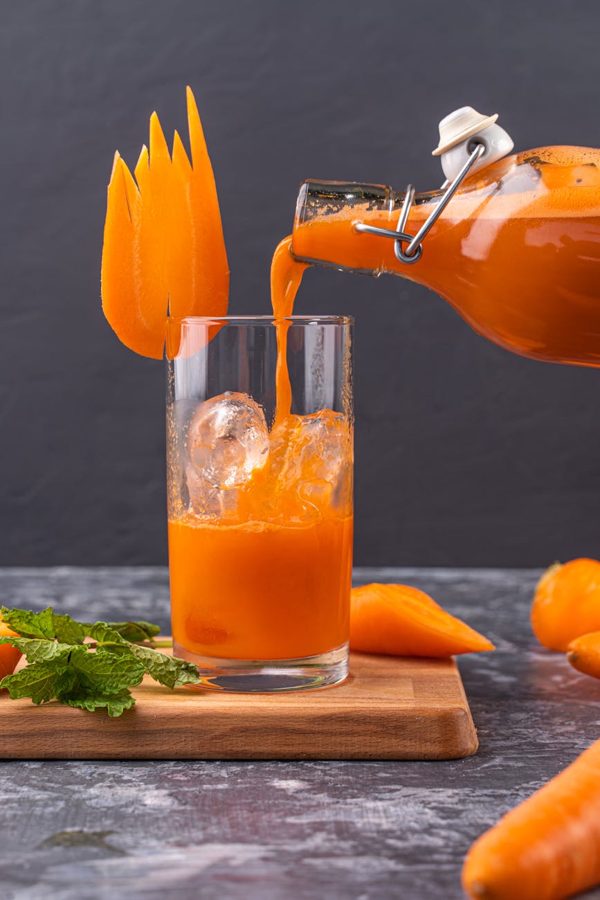 pouring carrot juice in the glass