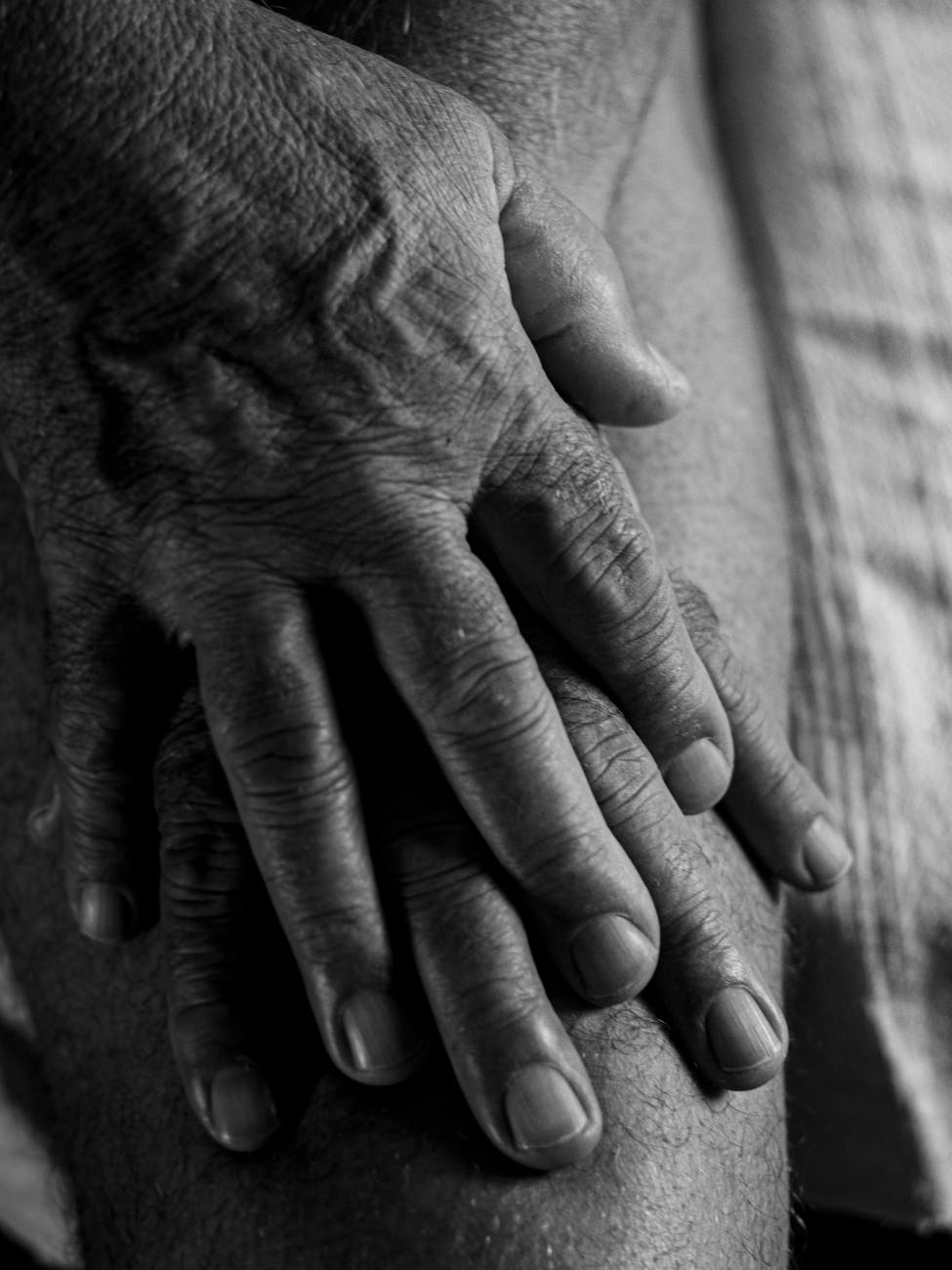 elderly man pressing his thigh with both hands